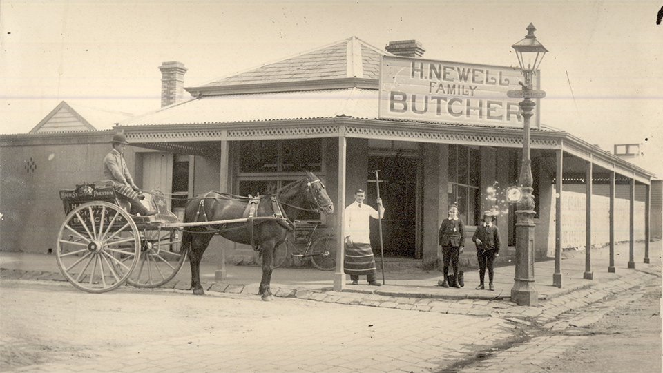 Old black and white photo of a horse and cart in front of a hotel