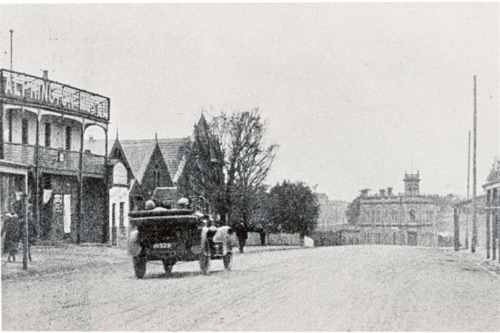 Image of a Car passing the Alphington Hotel. The Tower Hotel is visible in the centre of the photograph. [LHRN1038]