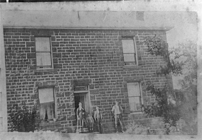 Image of Young Sam Dennis standing in front of 36 Walker Street with his parents William and Mary