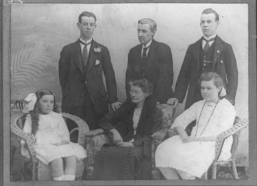 A studio portrait taken of the Nelson family c.1916.  Standing left to right: Ralph Walter (Wally), Ralph and Harry.  Seated left to right: Edna, Hannah and Alma.