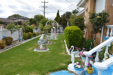 Margaret's front lawn heavily decorated with blue and white trimmings and white garden statues.