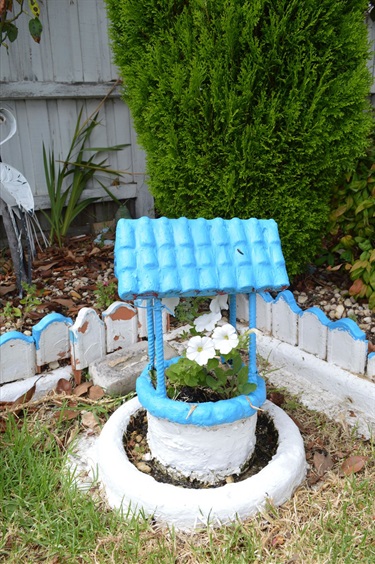 Margaret Simmons' Well is painted blue and white with white petunias