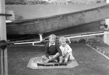 Brian Latham and Lynette Latham with a Triang-Hornsby train set in the backyard of 4 Storey Road, Reservoir, 1960 [LHRN5437-36]