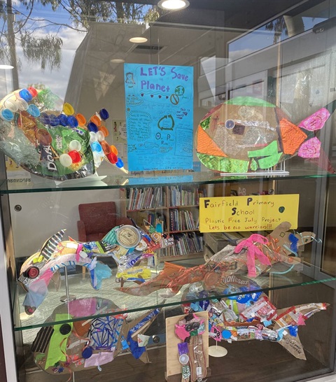 Photo of a glass cabinet with a series of sea creatures made from plastic waste on display. 