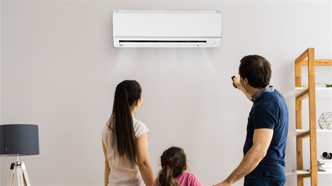 A young family turning on an air conditioning unit.