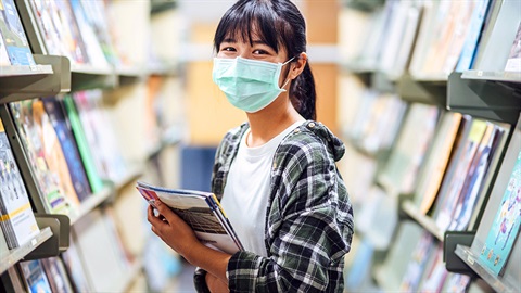 girl wearing a face mask inside the library